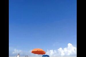 Butterfly tattoo on the pubis of a naked woman on the beach