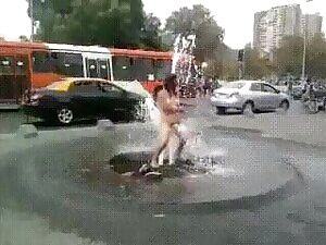 Drunk woman being washed or masturbated while sitting on a fountain in public