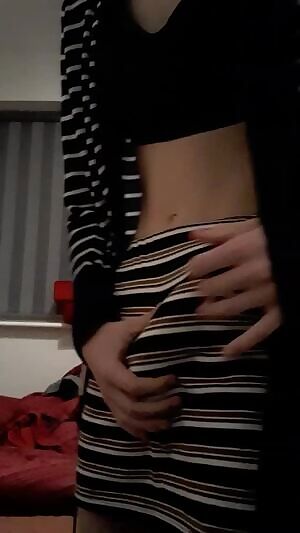 Shemale trying to hide her dick behind a skirt