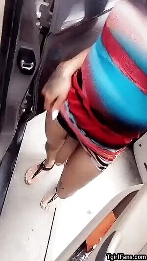 Showing her cock between two cars