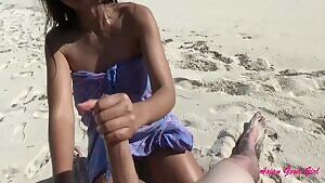 She makes him cum on the beach