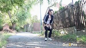 Isabel Dark, dressed in gym gear, relieves her pee desperation outdoors